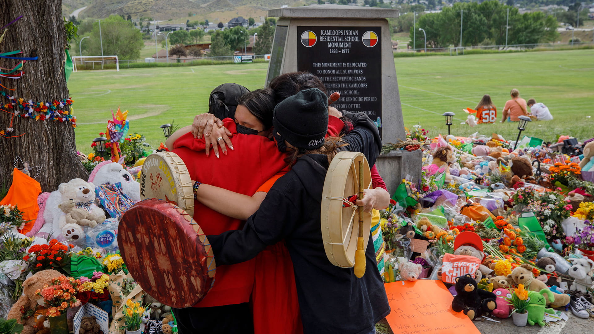 Group of people hugging one another at Native American Boarding School memorial